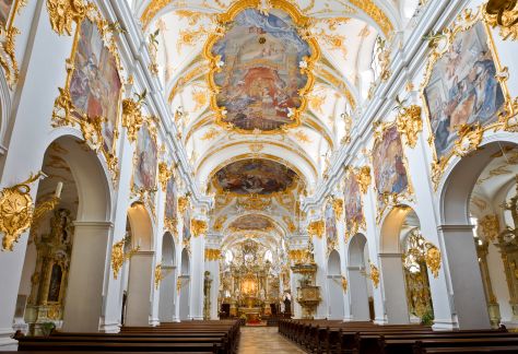 Opulent verzierter Innenraum einer Rokoko-Kirche, geprägt von muschelförmigen Rocaille-Ornamenten und übermäßiger Dekoration